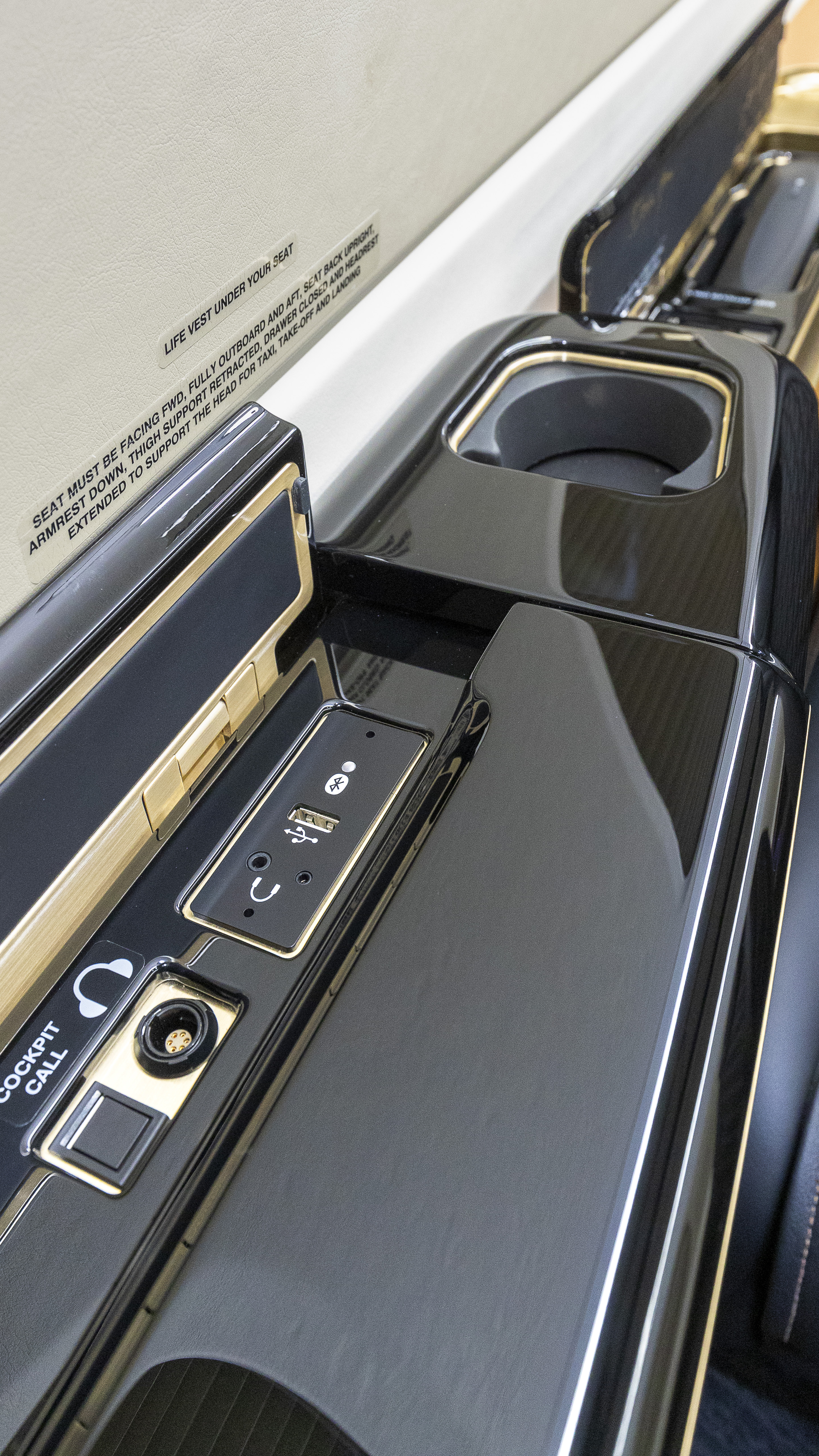 “Piano black” side panels have storage compartments.