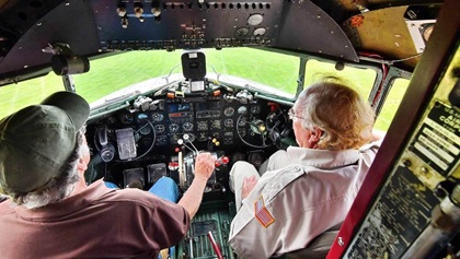 Captains Rob Gillman, left, and John Lindsay—two of the large team of pilots, co-pilots, and crew chiefs who fly the National Warplane Museum's C–47A, shepherd Whiskey 7 during Operation Thanks from Above on May 16 (top). Lou Horschel’s P–51 Mustang Mad Max and an RV–10 photo ship flown by Dan Maloney accompany the National Warplane Museum’s C–47A near Seneca Lake, New York, during Operation Thanks from Above (below). Tetamore Photographic