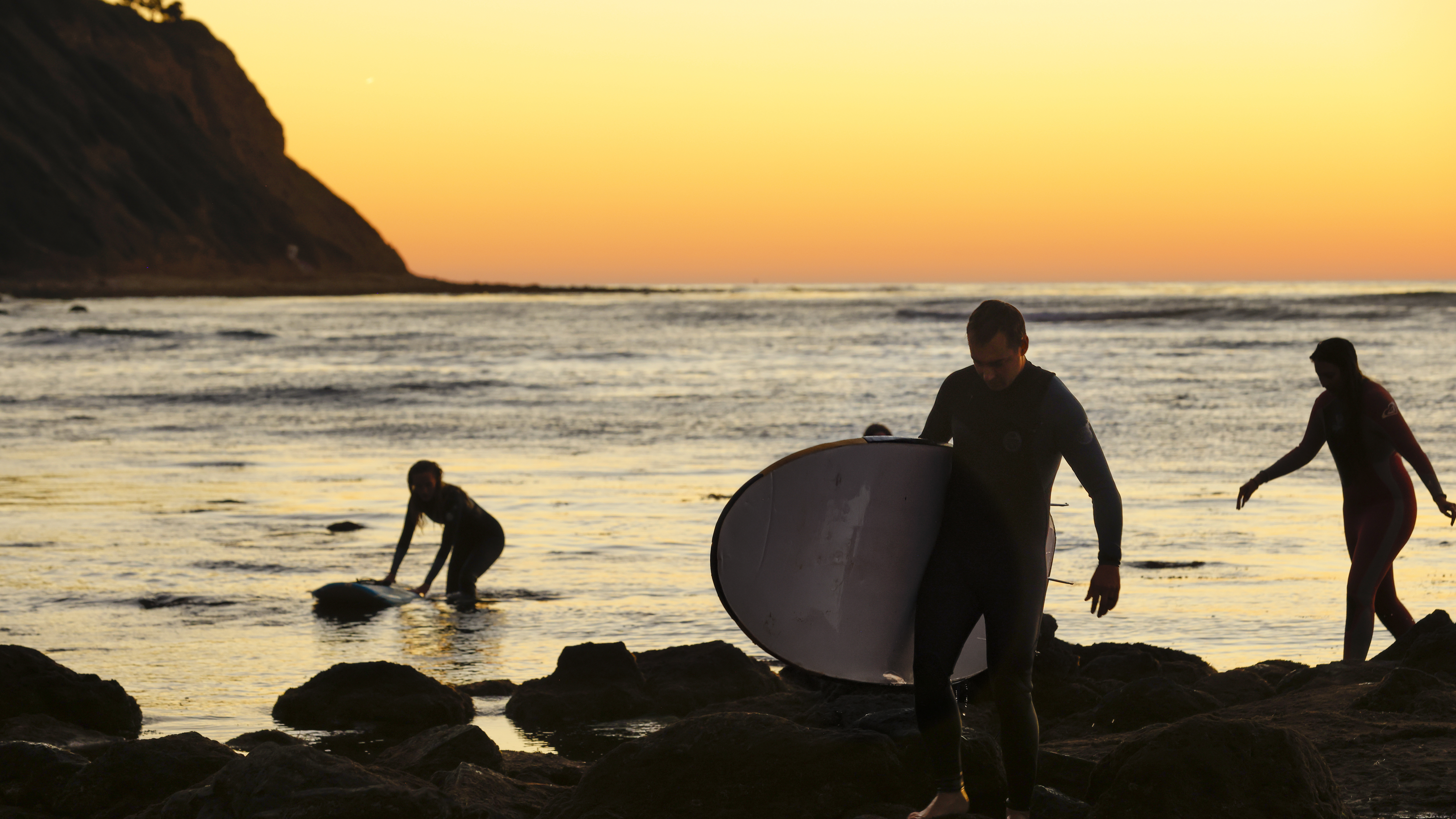 Gingerly stepping out of the water after sunset, making sure to avoid cutting our feet on the rocks.
