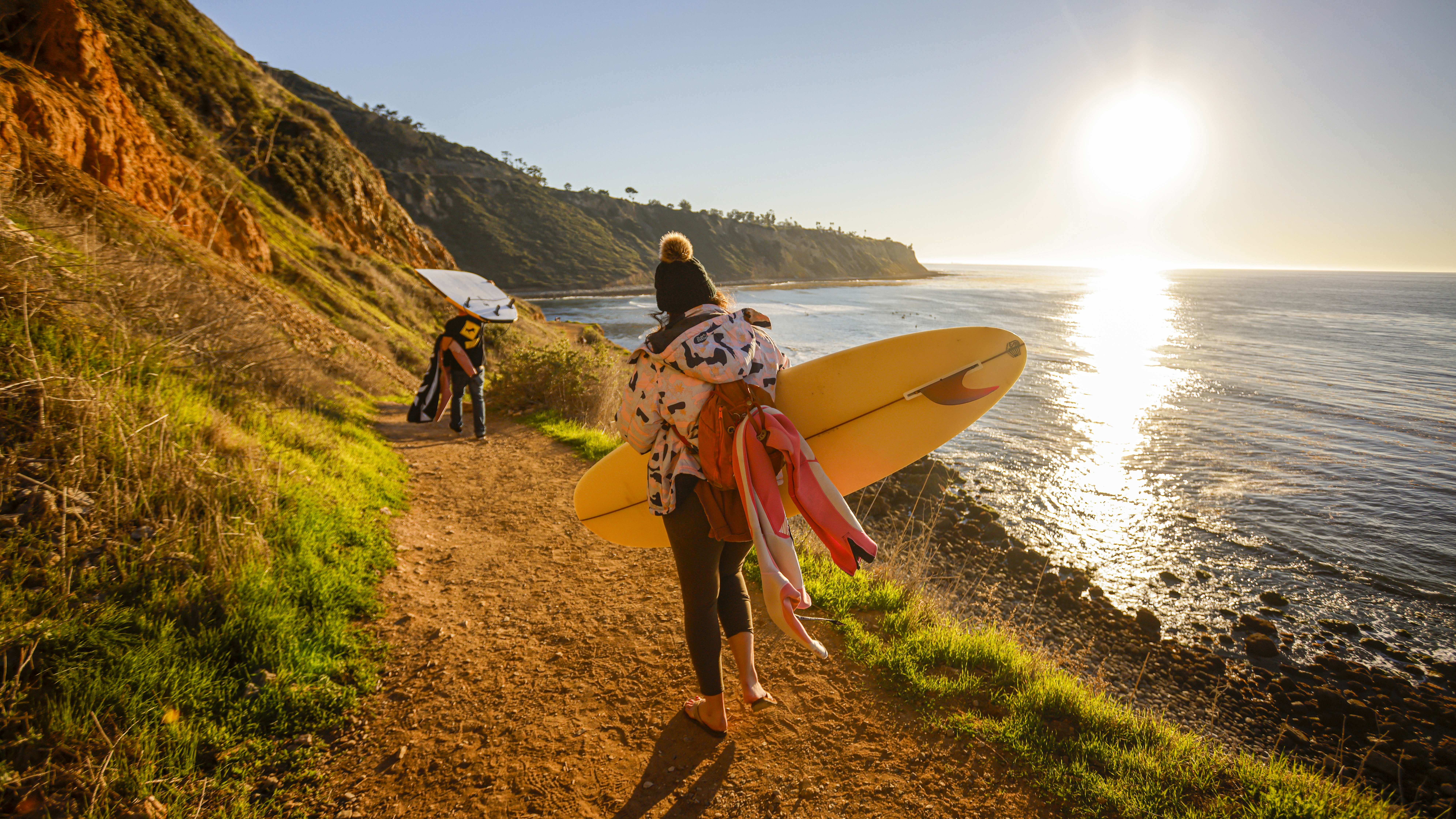 Walking down the trail with a ski jacket, beanie, flip flops, and a surfboard-just another day in California.