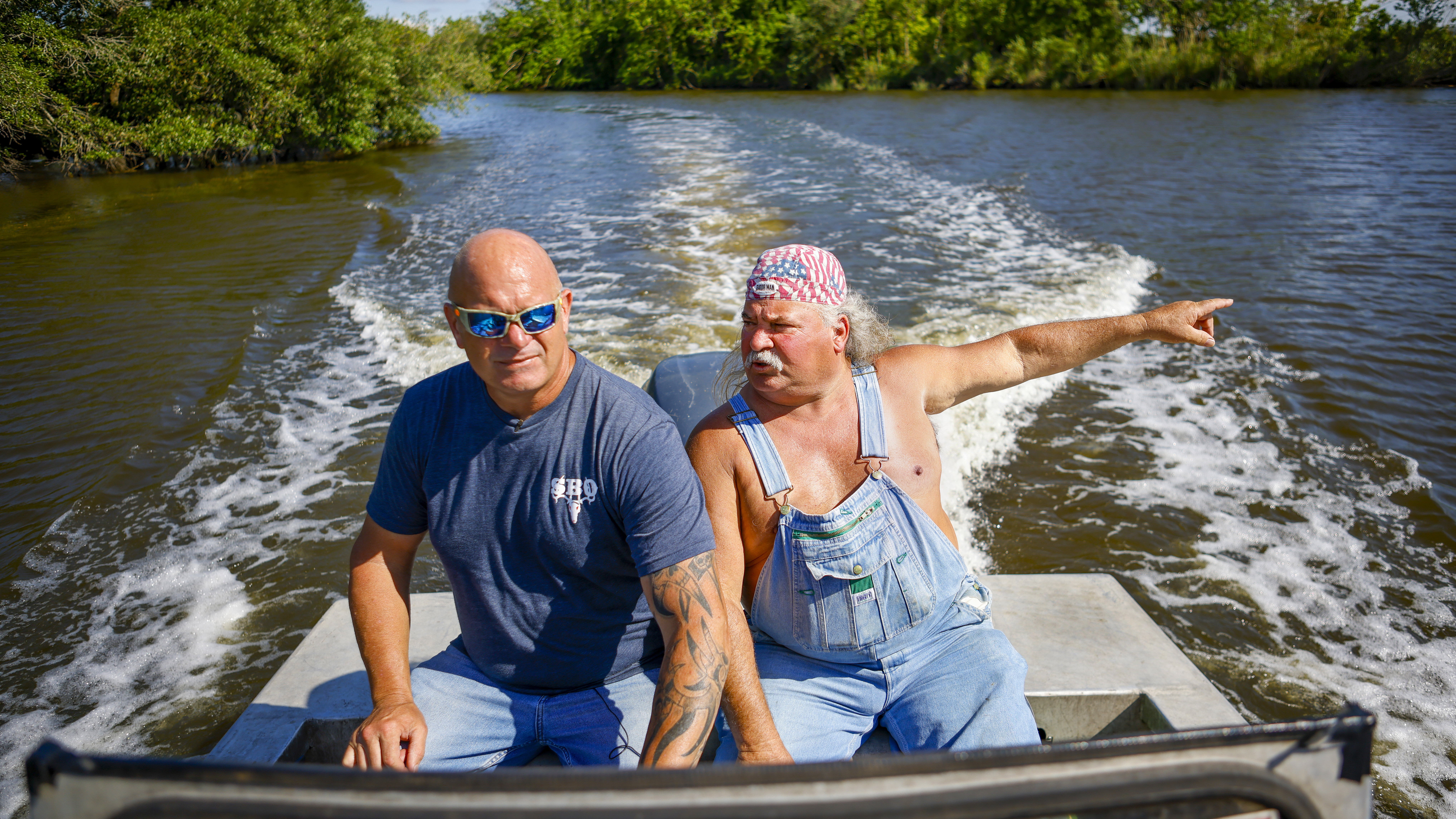 Ronnie Adams and Bruce Mitchell boat through the bayou, where Adams points out the spot where he removed a massive dead alligator for the television series 'Swamp People'.
