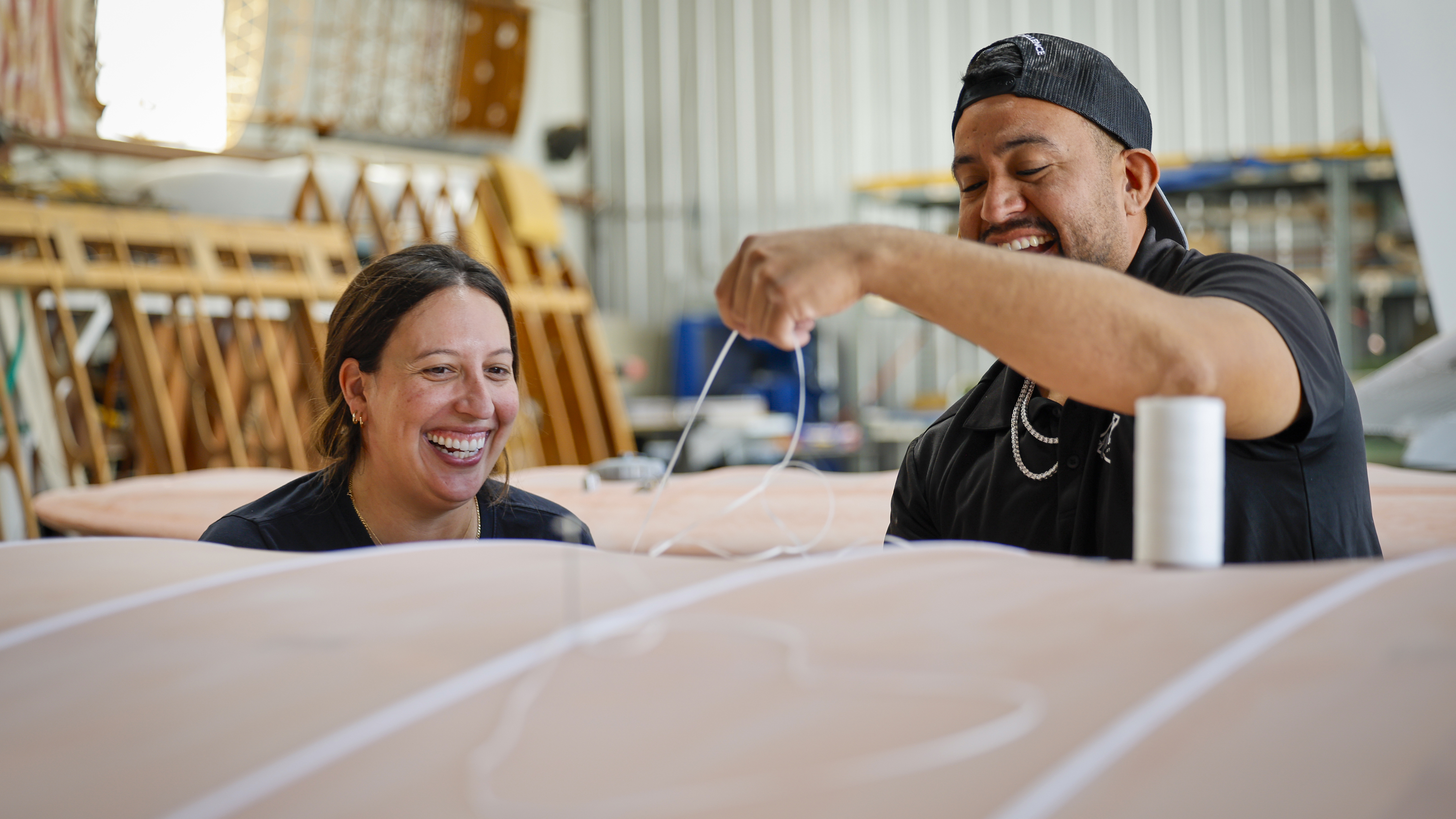 A patient Eric Rodriguez teaches the author to sew wing ribs.