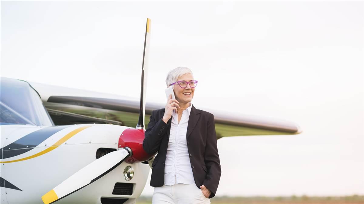 Businesswoman in front of private jet airplane waiting for flight