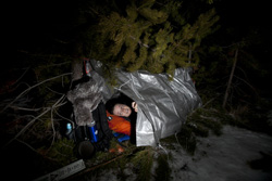 Survival huts can be as simple as a piece of tarp draped over a rope tied between trees.
