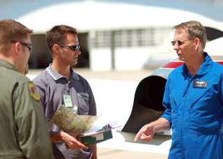 An instructor talks with students at the National Test Pilot School.
