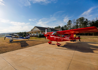 Designed from the beginning as a flight school, this beautiful home has two rooms for students and a large briefing and dining area. The red Xtreme is used by Greg Koontz in his airshow act aimed at showing the average pilot maneuvers he or she can do with just a little training.