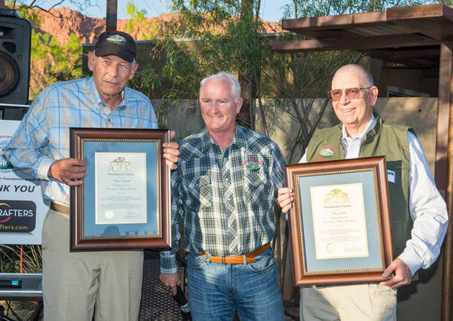 Chuck Jarecki (left) and Dan Prill (right) receive presidential citations from AOPA President Mark Baker. Photo by George Kounis.