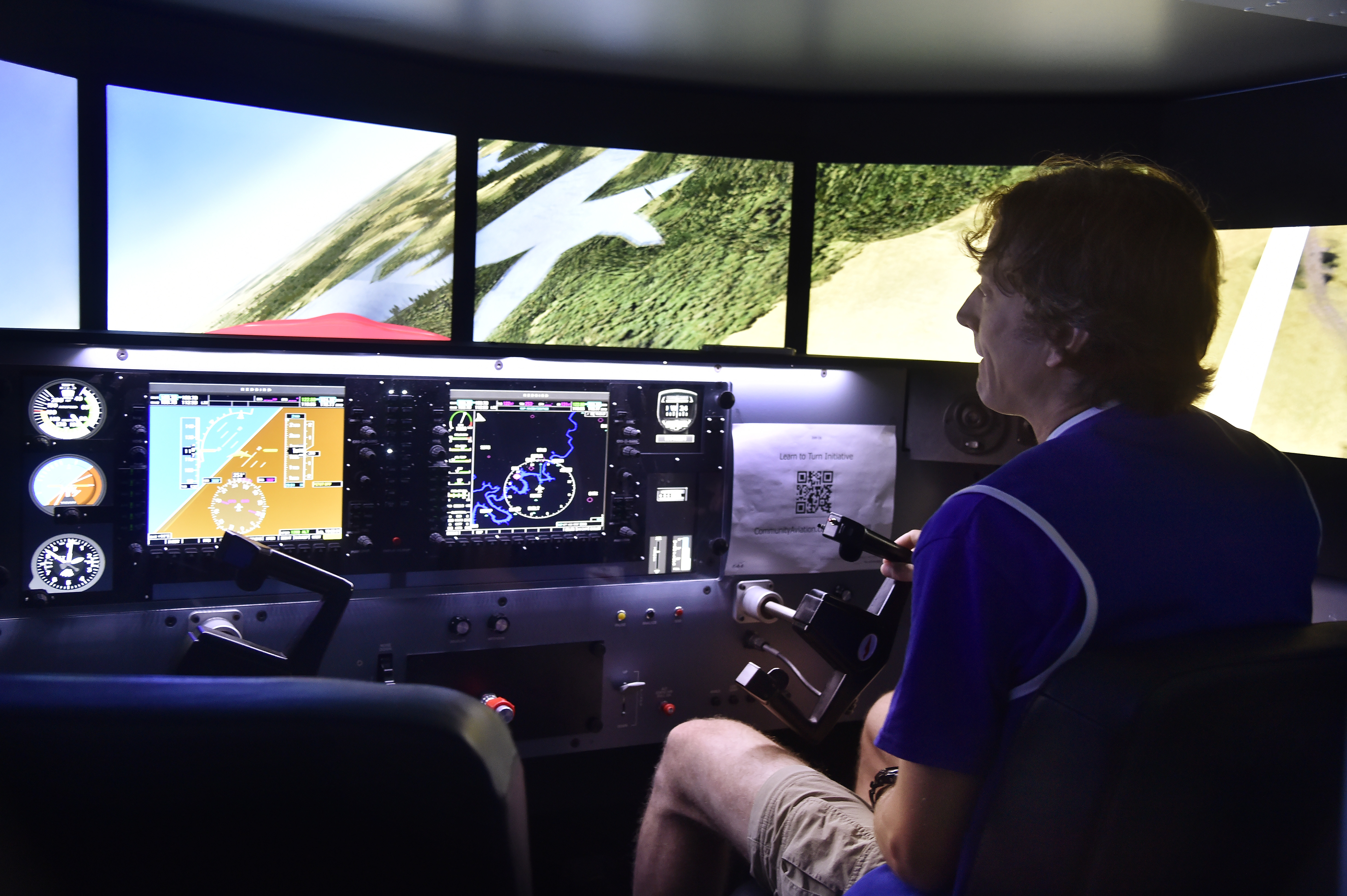 Flight instructor Jason Archer prepares a Redbird MCX full-motion simulator in the popular Pilot Proficiency Center during EAA AirVenture. Photo by David Tulis.