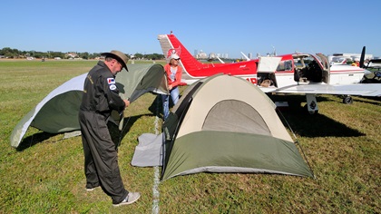 Buzz and Lori Hohmann of Zephyrhills, Florida, install the rain fly on their tent at the 2017 AOPA Tampa Fly-In. It was the first AOPA Fly-In the couple has attended. Photo by Mike Collins.