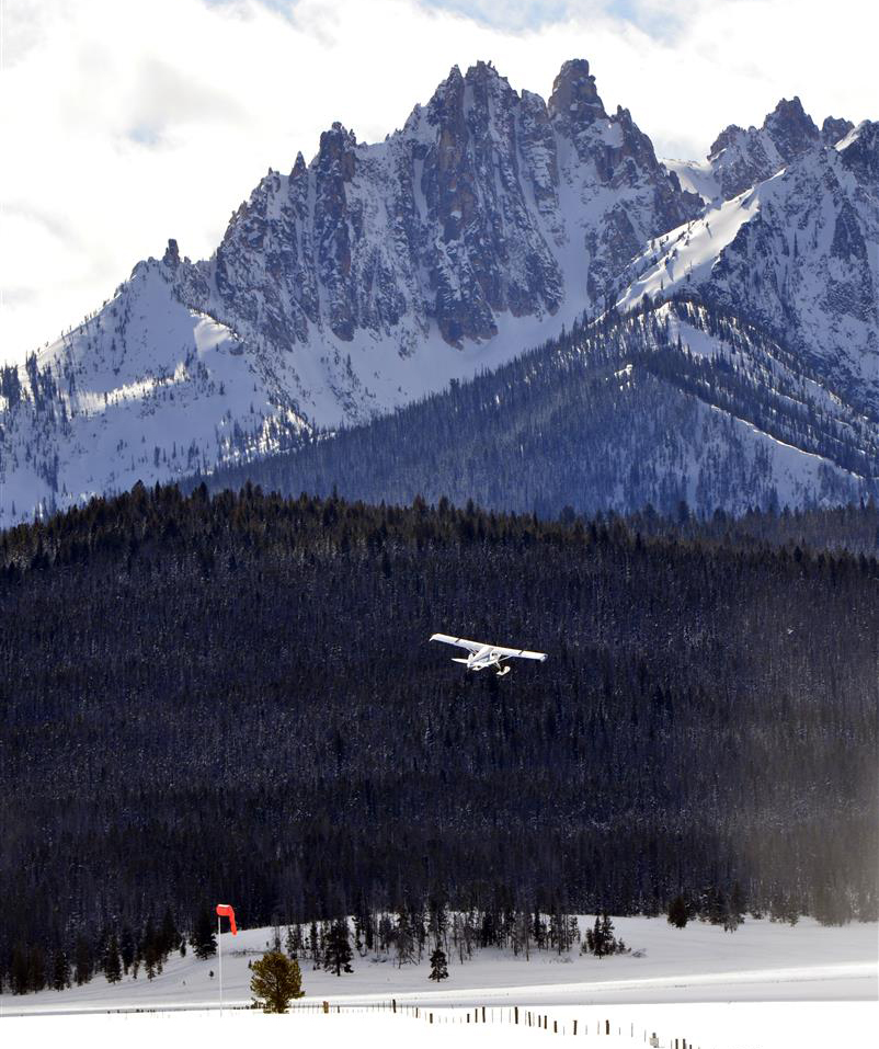 Against the dramatic background of the Sawtooth Mountains, a ski plane departs the snow runway at Stanley, Idaho, during the annual Stanley Ski Plane Fly-In, held each February. Photo by Santiago Guerricabeitia.