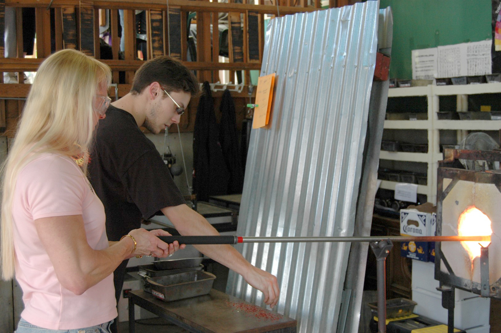 The author heats up a piece of glass which will be blown into a paperweight shaped like a heart. Fred Worthy photo.