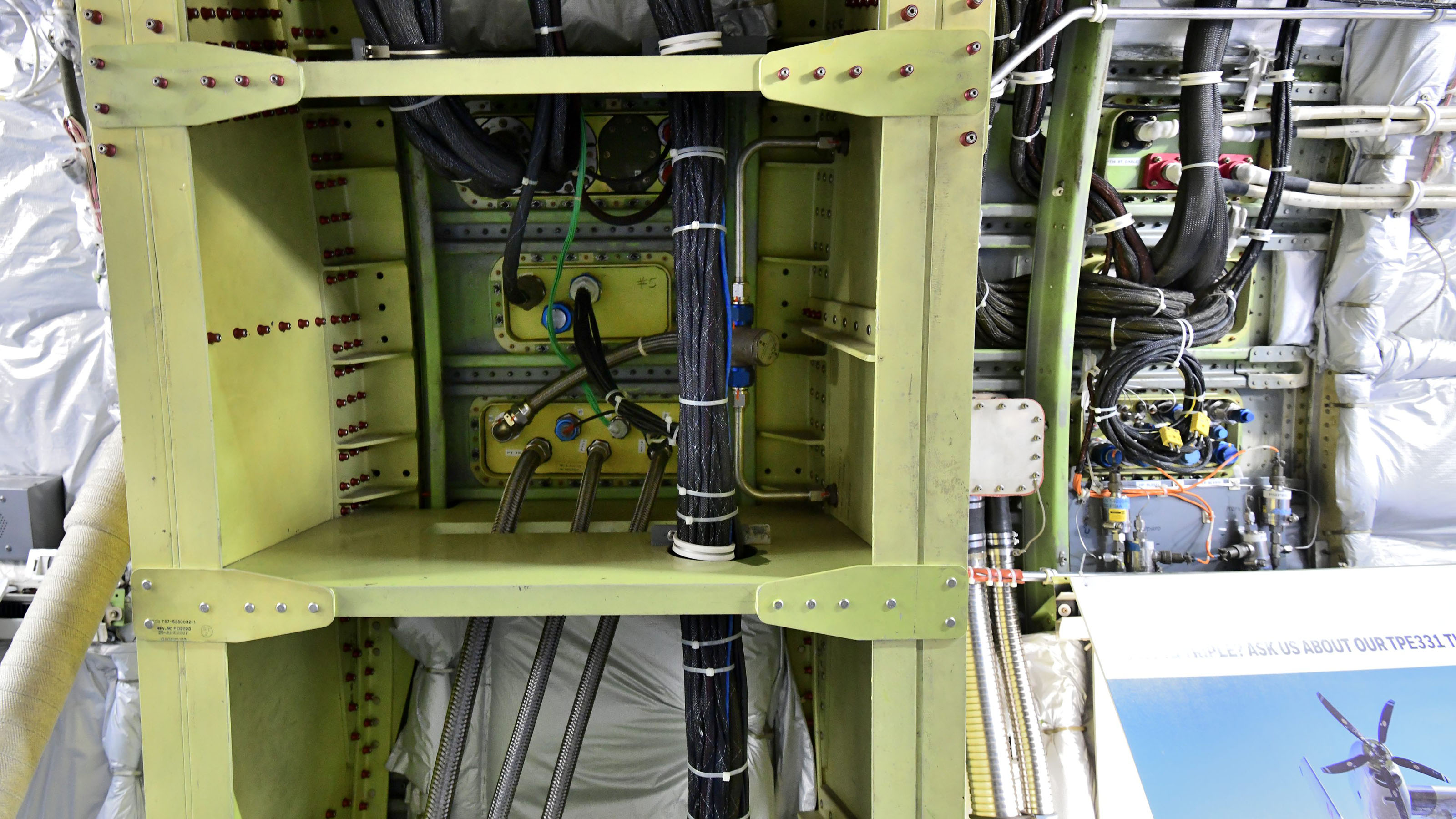 The green metal is additional structure added to Honeywell's Boeing 737 test bed to support the test engine. Inside and to the right are passthroughs for fuel, bleed air, and data feeds. Photo by Mike Collins.