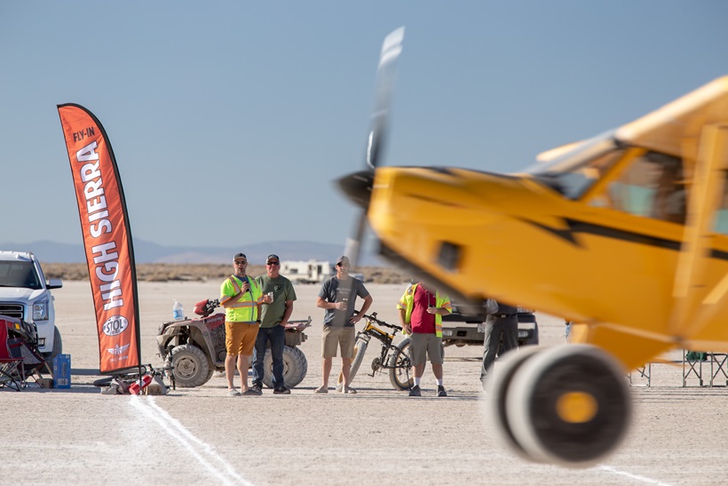 An aircraft is inches above the ground as judges inspect a landing at the turn-around during the 2018 High Sierra Fly-In STOL Drag Race. Photo by Mike Fizer.