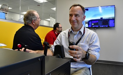 AOPA 2018 Flight Training Experience Award-winning best CFI Mike Biewenga of Blue Skies Flying Service near Chicago, tries his hand at 'blind flying' a Redbird Jay flight simulator with coaching from his team during Redbird Migration at the AOPA You Can Fly Learning Center campus in Frederick, Maryland, in 2018. Photo by David Tulis.