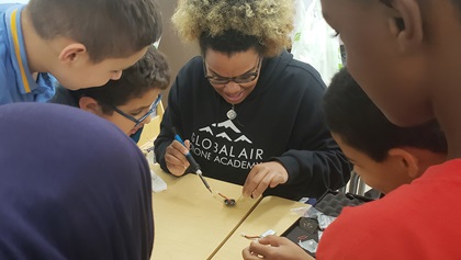 A Global Air Drone Academy instructor shows students how to solder a drone controller board at a camp in Abu Dhabi, UAE. Photo courtesy of Global Air Media.