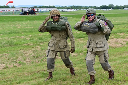 Liberty Jump Team jump master Butch Garner and jumper James Pearson salute after parachuting from a C-47 during the AOPA Frederick Fly-In and eightieth anniversary celebration. Photo by David Tulis.