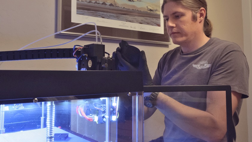 Hal Gates, an engineer for Tamarack Aerospace, uses a 3-D printer that has been making protective face masks for a local hospital. Photo courtesy of Tamarack Aerospace.