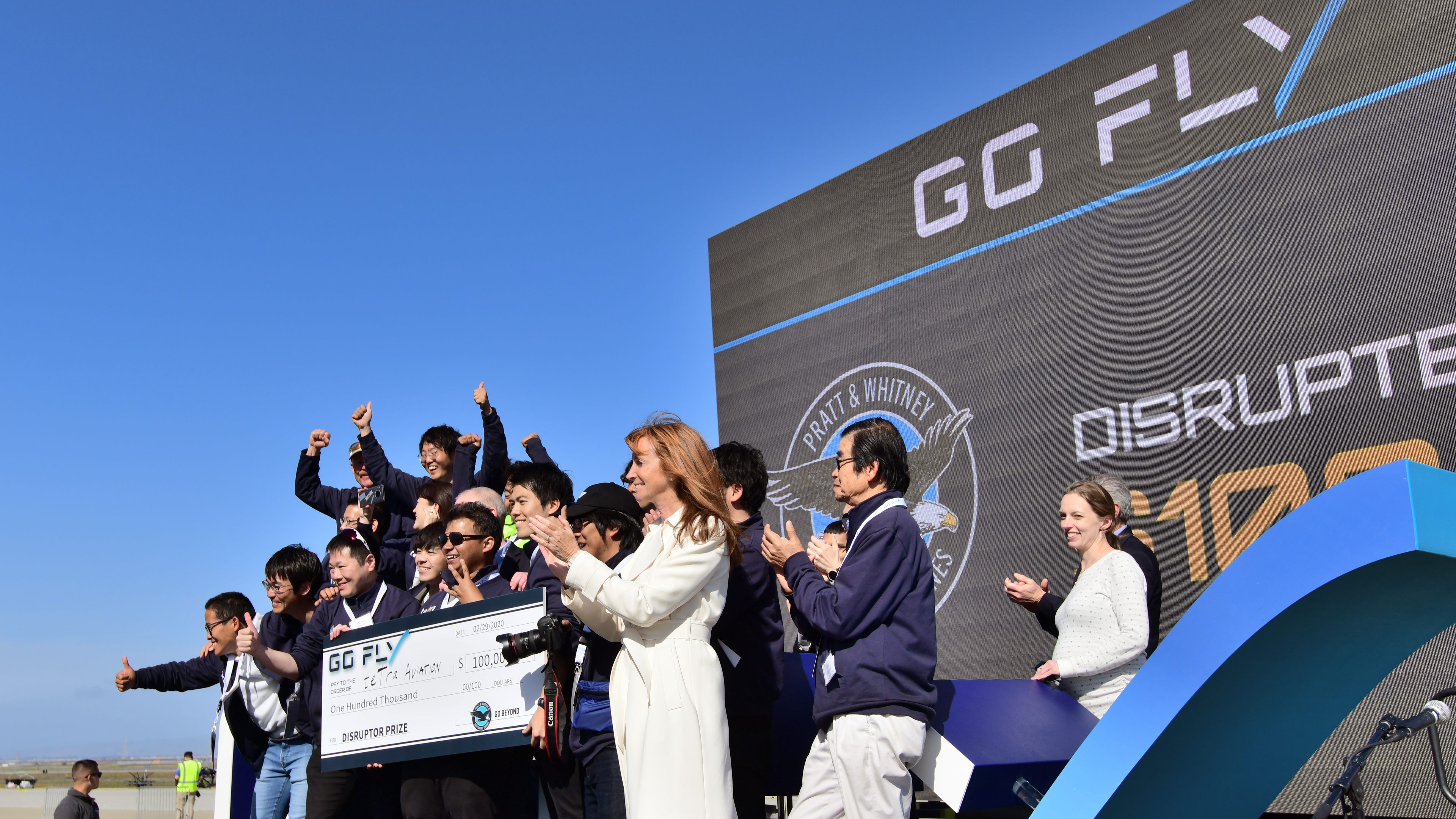 Members of Team teTra join GoFly Founder and CEO Gwen Lighter, wearing white at center, after she announced that they won Pratt & Whitney's $100,000 Disruptor award. The $1 million GoFly Prize was not awarded and remains available. Photo by Mike Collins.