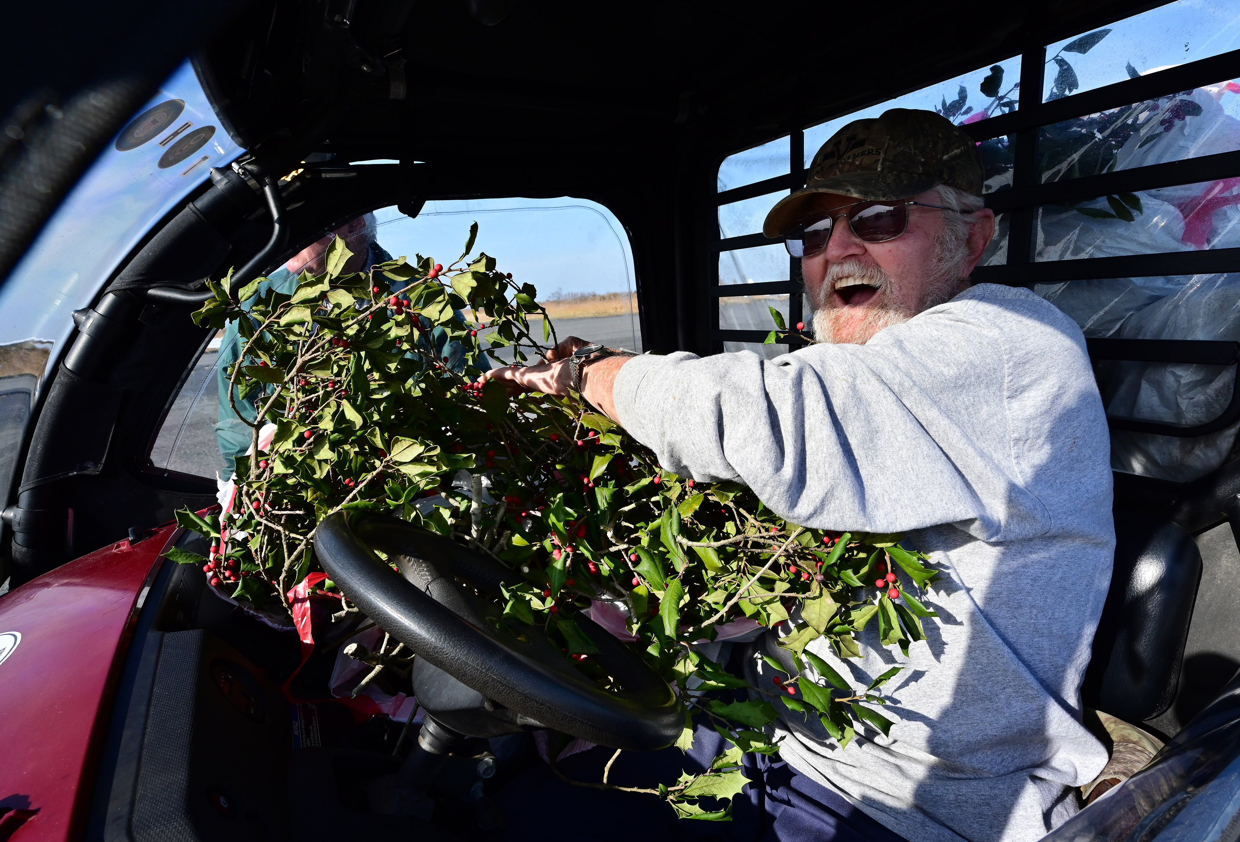 Tangier Island, Virginia, resident Larry Pruitt loads up holly branches delivered by general aviation pilots to the fishing village on the island during the annual Holly Run fly-out. Photo by David Tulis.                                                                                   