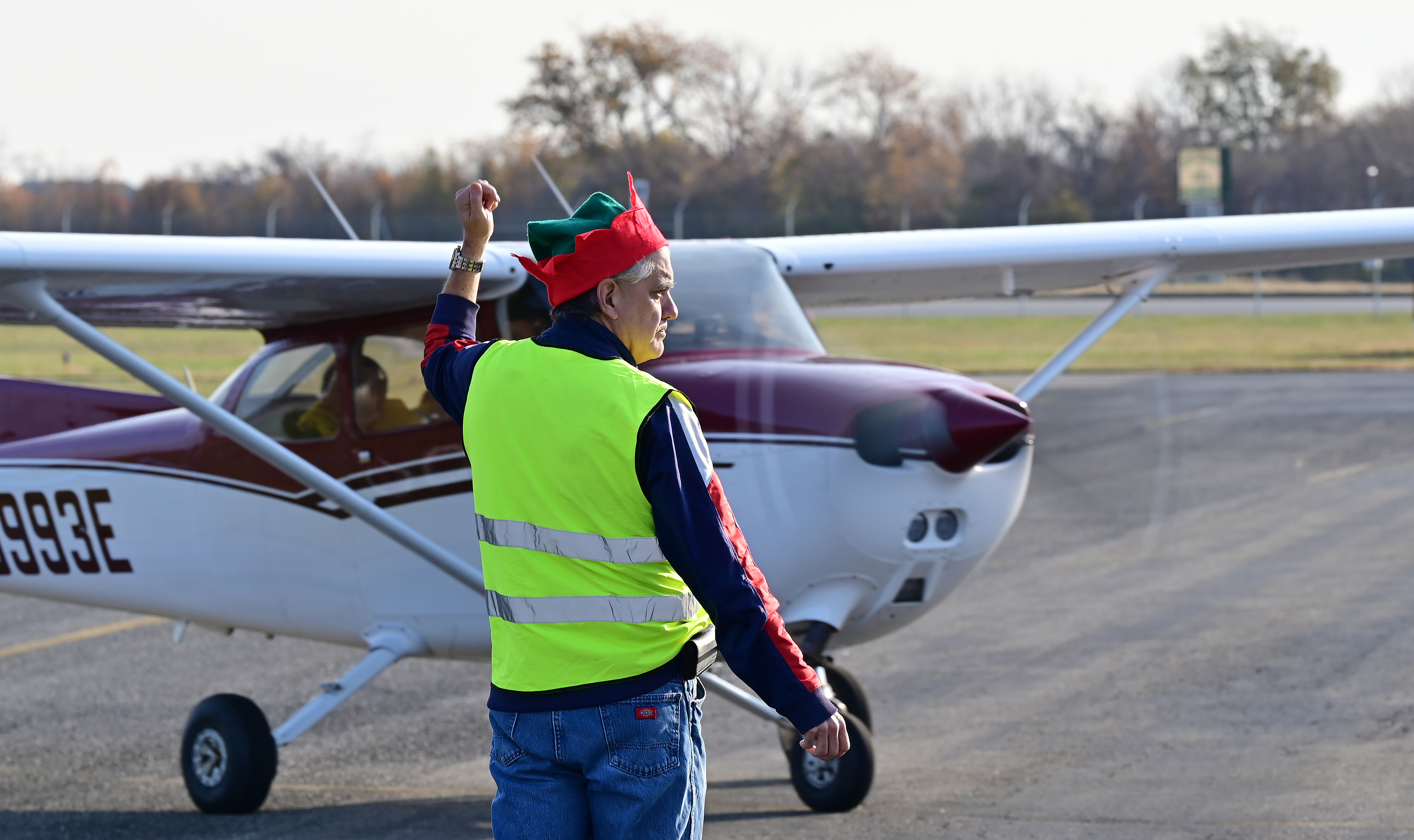 Parking elf Greg LaFave directs a pilot to a pancake breakfast at Bay Bridge Airport in Stevensville, Maryland, to begin a charity fly-out to Tangier Island, Virginia. Photo by David Tulis.                                                                                                  