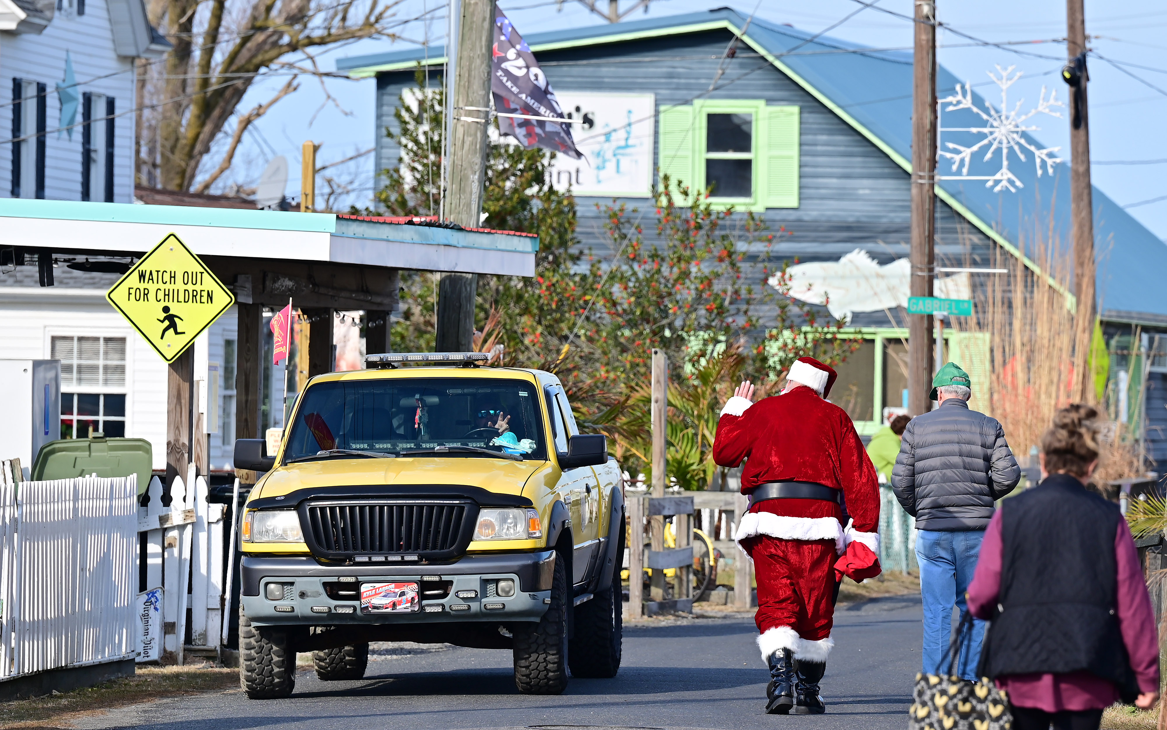 Santa Claus and general aviation pilot Ralph Hoover waves to Tangier Island, Virginia, residents after delivering holly branches, school supplies, and presents to the island’s population of 400. Photo by David Tulis.                                                                     