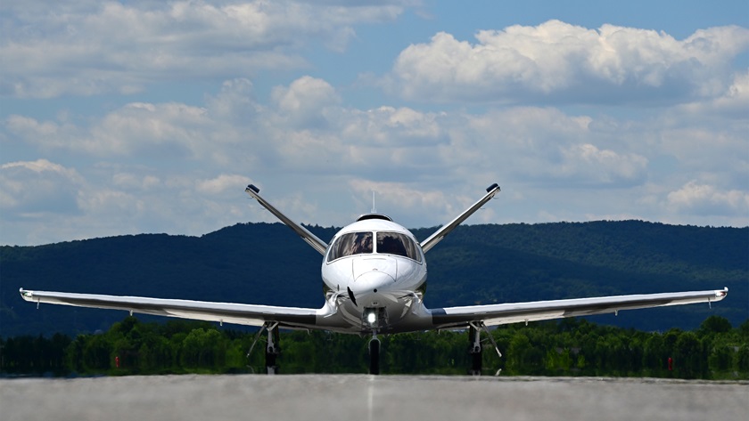 A Cirrus Vision Jet G2+ is framed by mountains near the Runway 12 threshold at Frederick Municipal Airport, June 23, 2021. Photo by David Tulis.