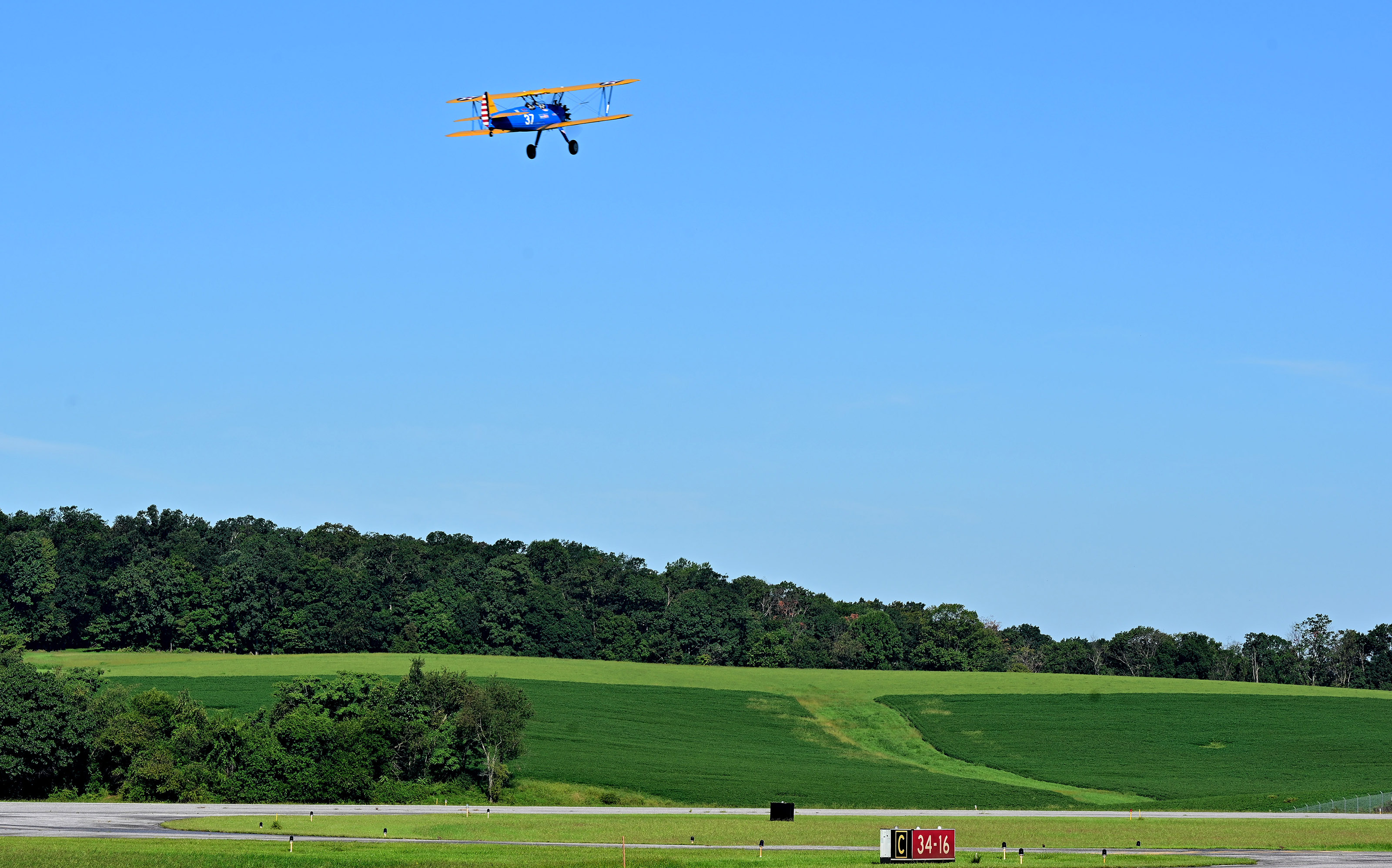 A Boeing Stearman military trainer operated by Dream Flights pilot Marcus Smith departs for an honor flight with World War II veteran James Miller at Carroll County Regional Airport/Jack B. Poage Field in Westminster, Maryland. Photo by David Tulis.