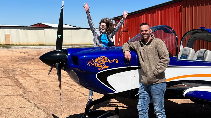 AOPA social media marketer Cayla McLeod jumps for joy at the prospect of flying the AOPA Sweepstakes Tiger. Photo by Keven Sasser.