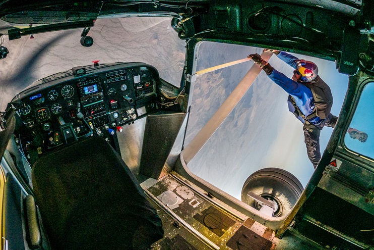 Pilot-skydiver Luke Aikins holds onto the strut of the unoccupied Cessna 182 during the Red Bull "Plane Swap" attempted during a livestream event April 24. Photo courtesy of Red Bull Content Pool.