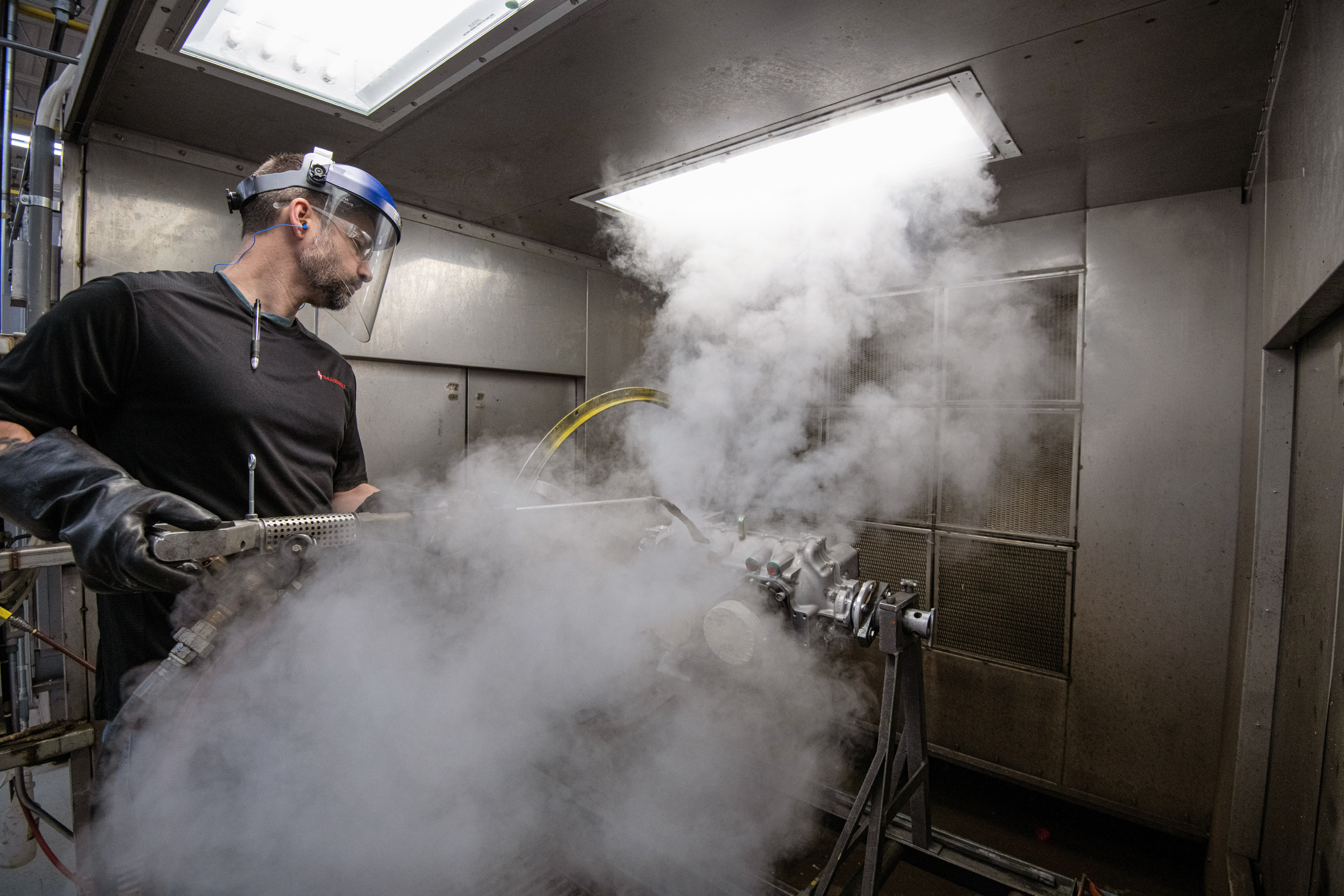 Paul Zener, who grew up working on his own cars and motorcycles, cleans the outside of a Lycoming engine he helped build from the ground up. Photo by Mike Collins.