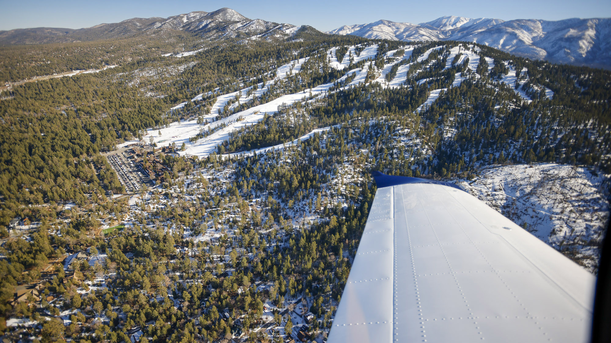 Bear Mountain Resort off our wing with the snowy peaks of the San Gorgonio wilderness behind. Photo by Alicia Herron.