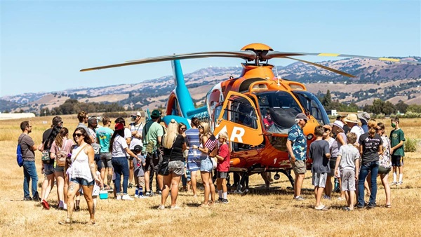 Parents and children crowd around an Airbus Helicopters H135 to meet the Calstar crew during the San Martin Airport's Food Truck Fly-In. Photo by Joshua Lapum Photography.
