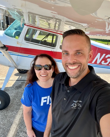 AOPA Social Media Marketer Erick Webb and AOPA High School Aviation Initiative Manager Karla Smith pose for a selfie under the wing of the AOPA Sweepstakes Cessna 170 at Tullahoma Regional/Wm Northern Field  in Tennessee. Photo by Erick Webb.