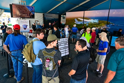 Pilots and enthusiasts lined up for a virtual reality experience at AOPA's main tent at EAA AirVenture Oshkosh. Photo by David Tulis.