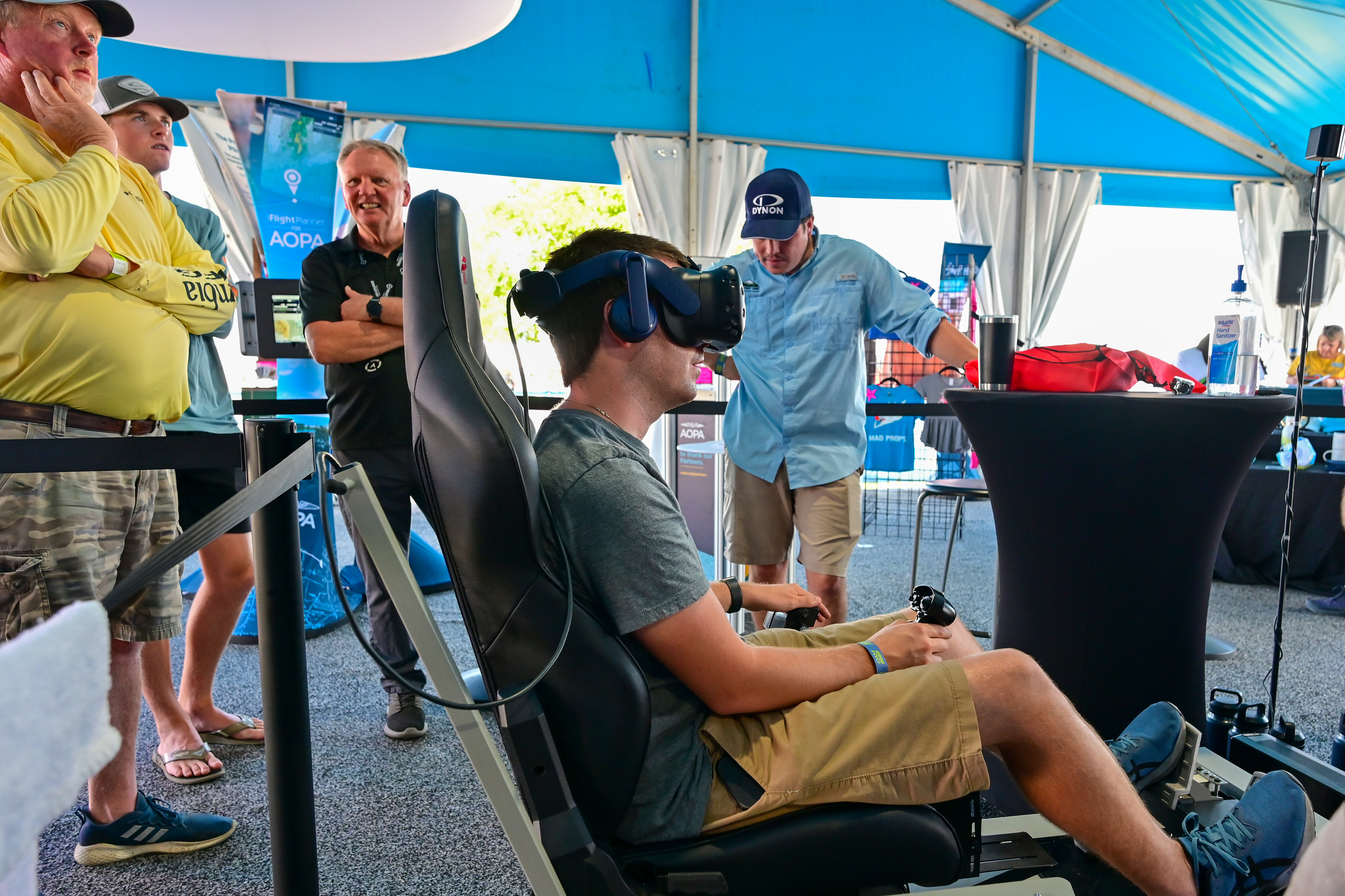Attendees take turns flying in virtual reality at the AOPA campus during EAA AirVenture Oshkosh July 25. Photo by David Tulis.