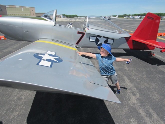 A young visitor checks out a Van's Aircraft RV-8 on display at Boire Field at a previous barbecue fly-in. Photo courtesy of the Aviation Museum of New Hampshire.