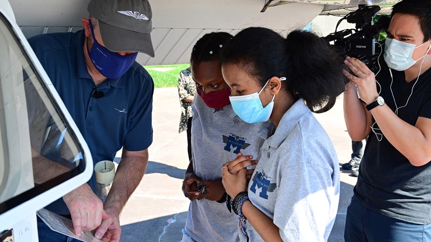 Chris Moser, AOPA senior director of flight training education, explains Cessna 172 preflight procedures to aviation STEM students Victoria Wentt and Ruth Gebremariam before a discovery flight at Frederick Municipal Airport on August 18, 2020. An ABC camera crew documented the flight for a segment on Sisters of the Skies, a group that encourages more Black women in aviation. Photo by David Tulis.