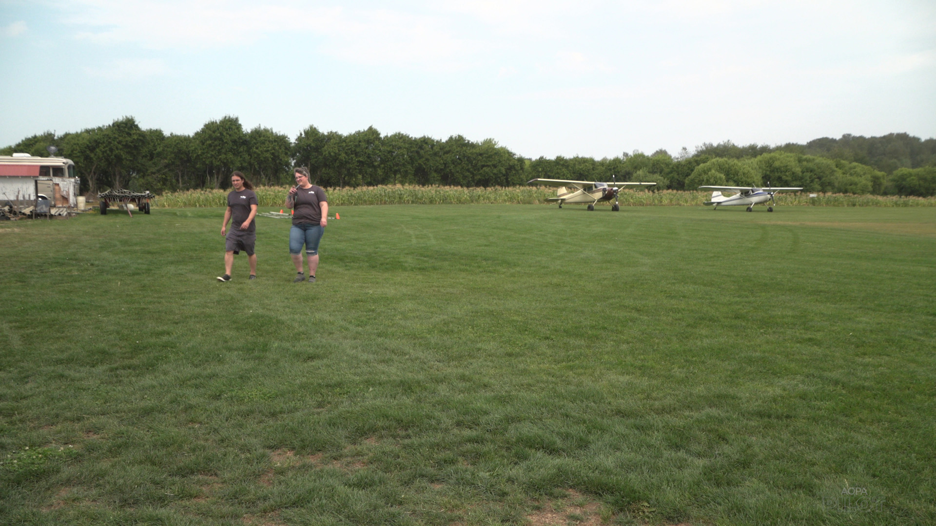 Teagan LaPointe, left, and Kristyn Blocher walk from their respective Cessna 170s after landing at Chapman Farms. Image by Sierra Harrop.
