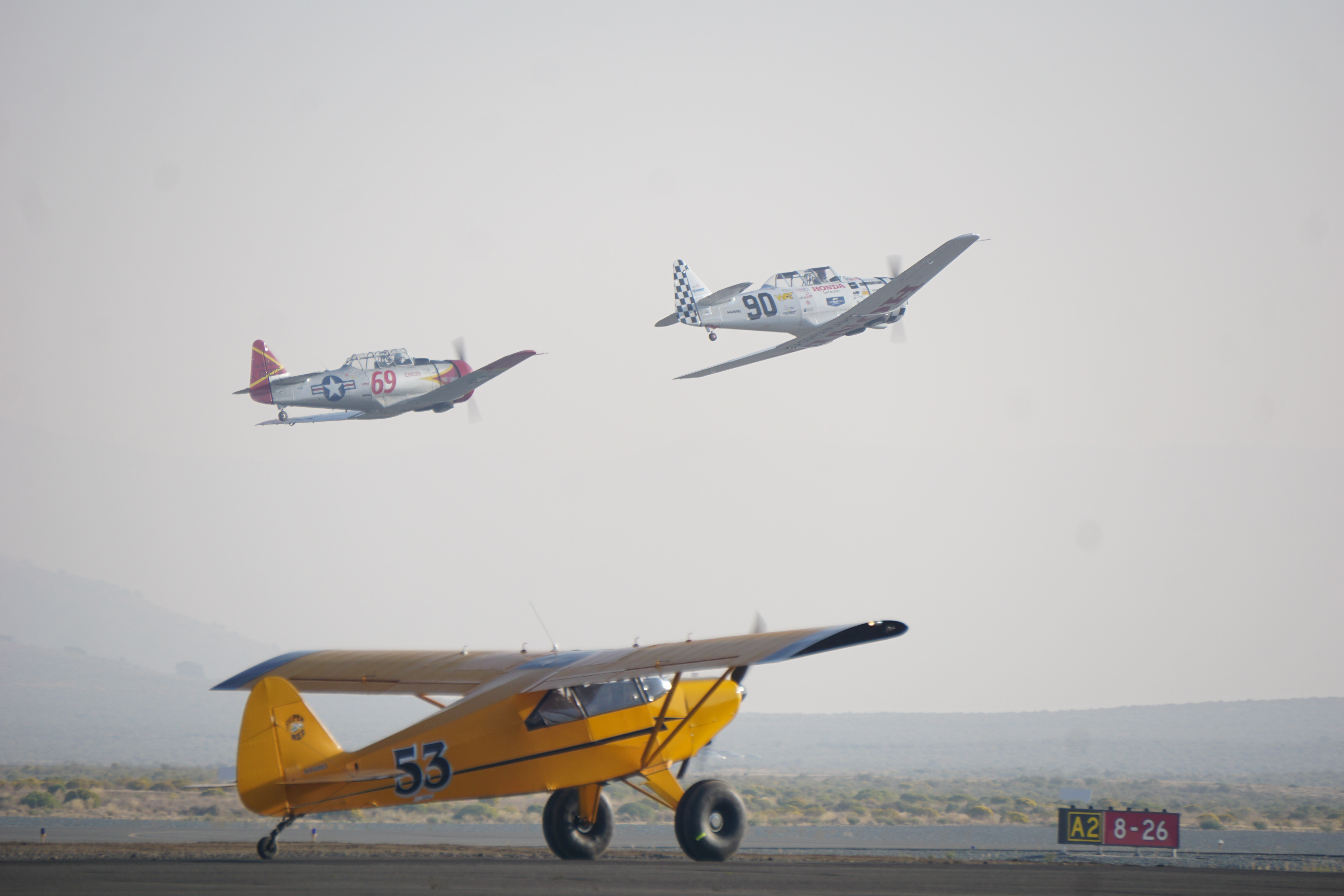 Two North American T–6 Texans depart to begin a smoky race. Photo by Cayla McLeod Hunt.