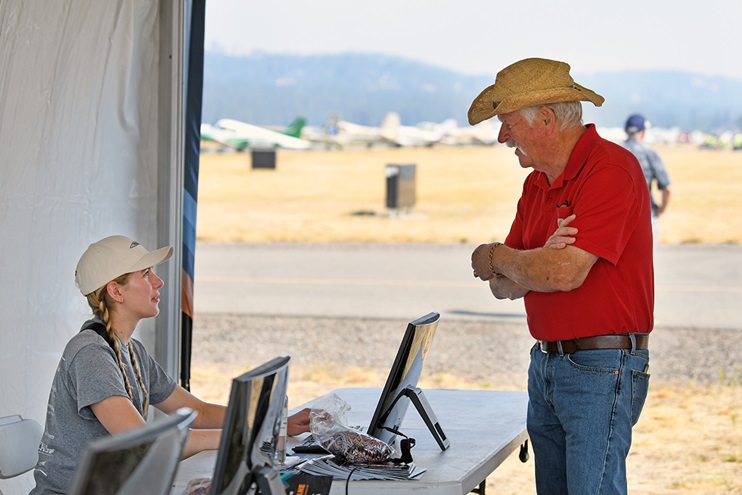 AOPA showside volunteer Sara Schwegel checks-in a Fly-in attendee at Felts Field in Spokane, Washington, September 10, 2022. Photo by Niki Britton.
