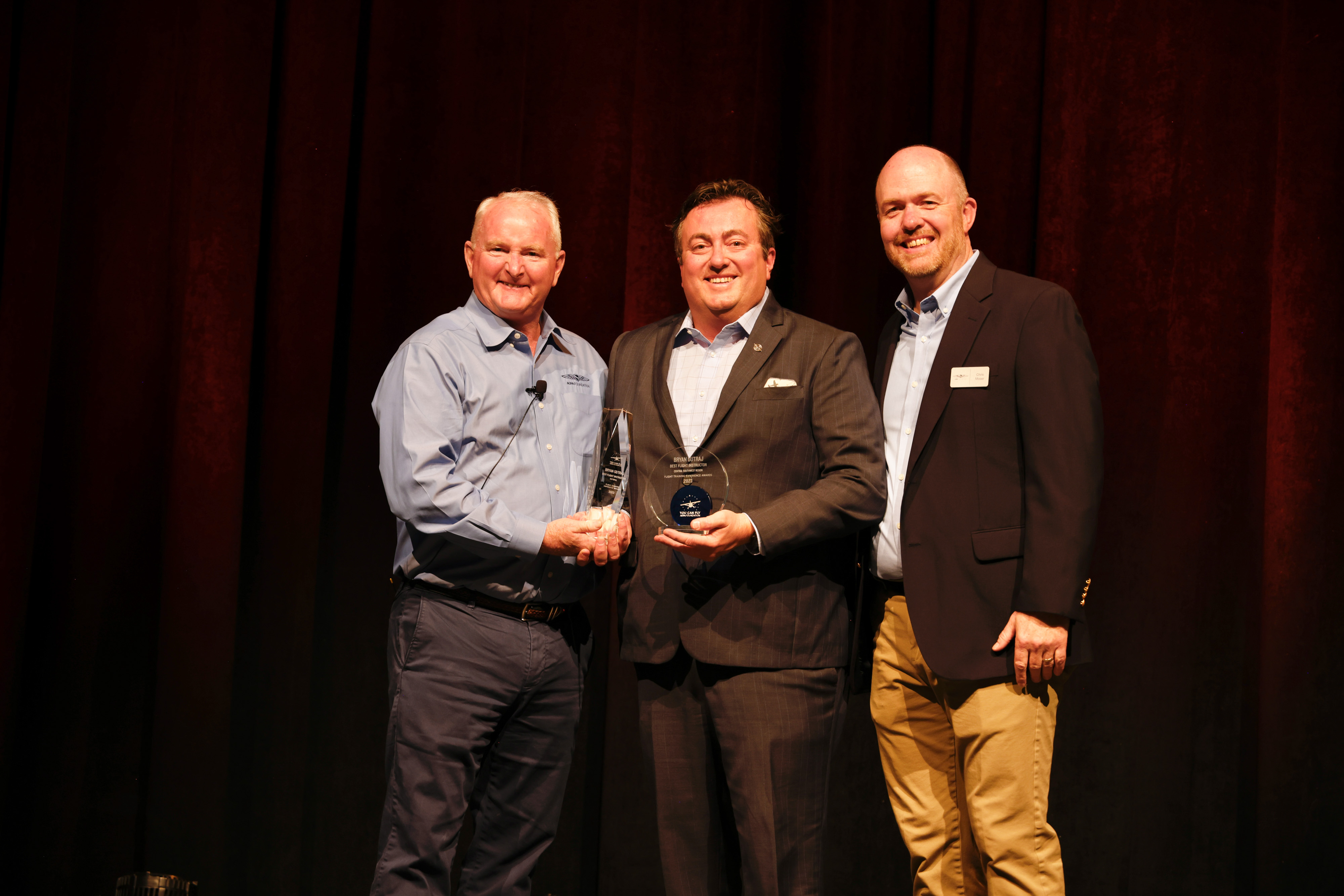 AOPA President Mark Baker and AOPA Foundation Senior Director of Flight Training Education Chris Moser congratulate the national best flight instructor, Bryan Gutraj. Photo by Chris Rose.