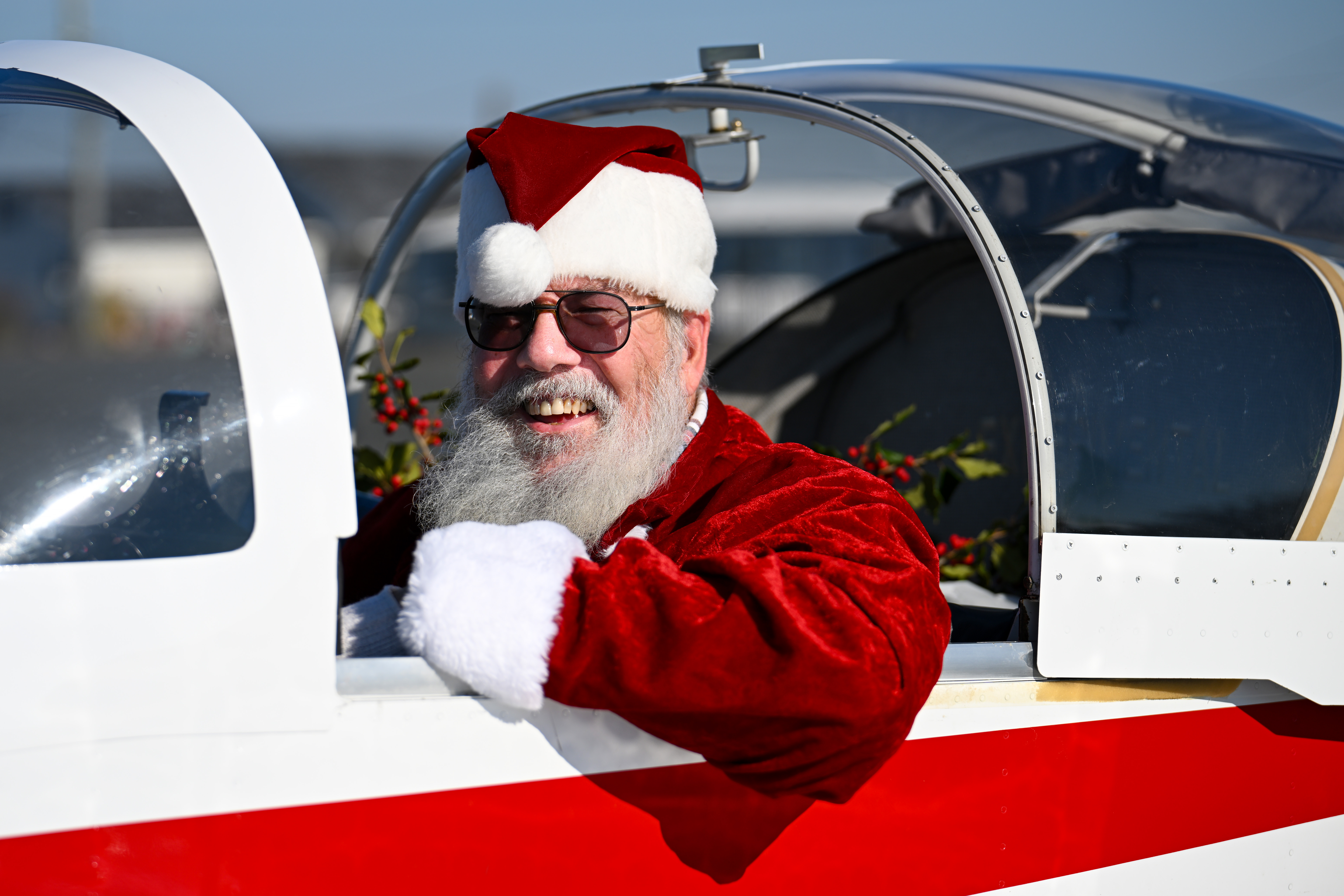 Santa Claus a.k.a. pilot Ralph Hoover leads more than 30 aircraft and pilots to Tangier Island, Virginia, to deliver holly branches and school supplies during the annual Holly Run charity fly-out. Photo by David Tulis.
