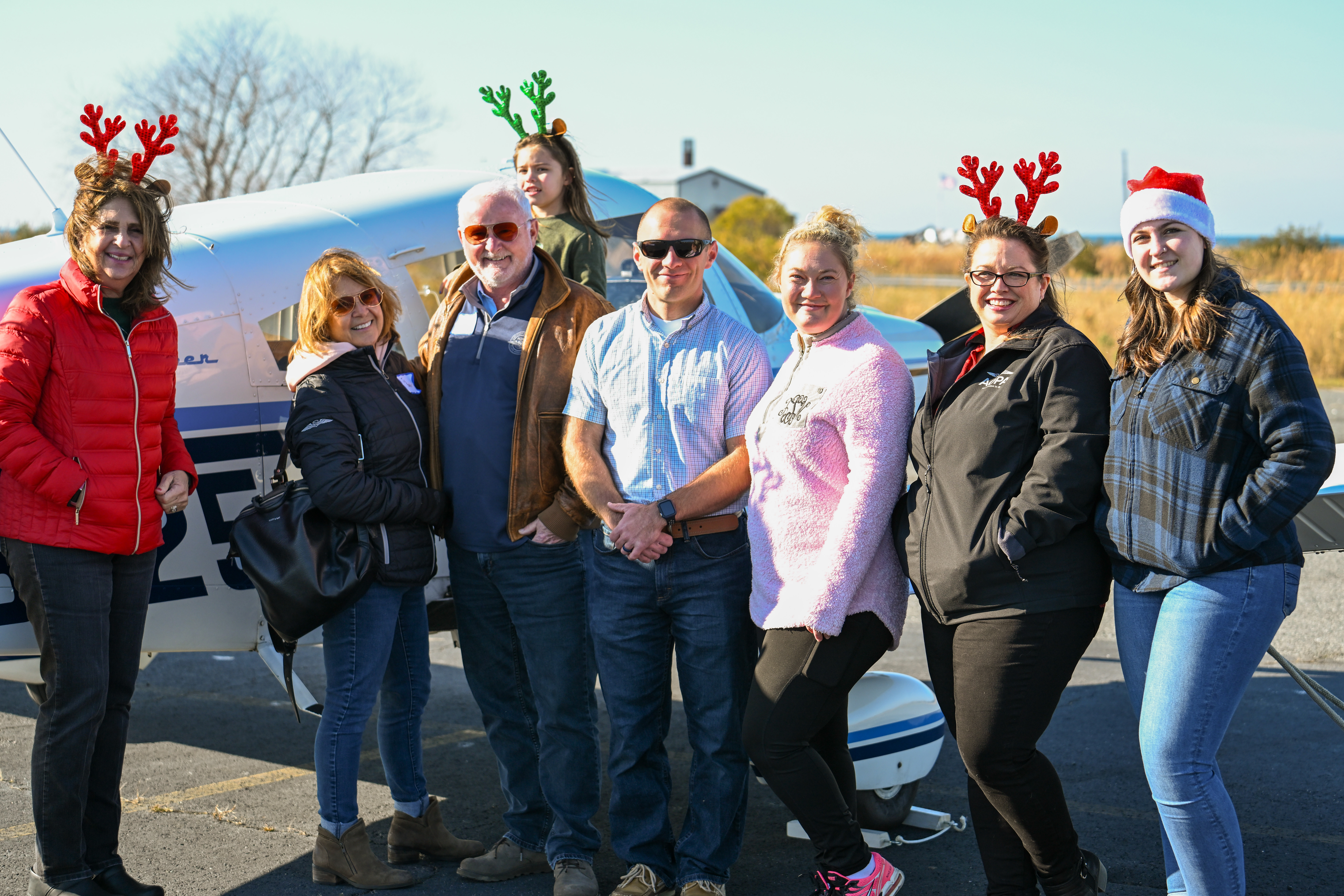 AOPA President Mark Baker and his wife JoAnn join Piper Cherokee 180 pilot Jonathan Brummitt, Tina Silva, Silva’s daughter Emma, and members of the AOPA Pilot Information Center who helped deliver holly branches and school supplies during the annual Holly Run to Tangier Island. Photo by David Tulis.