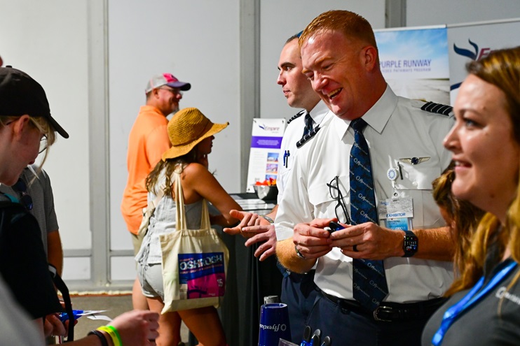 Pilots with the flyExclusive private jet firm answer questions during an aviation job fair at EAA AirVenture Oshkosh in Wisconsin on July 24. Photo by David Tulis.