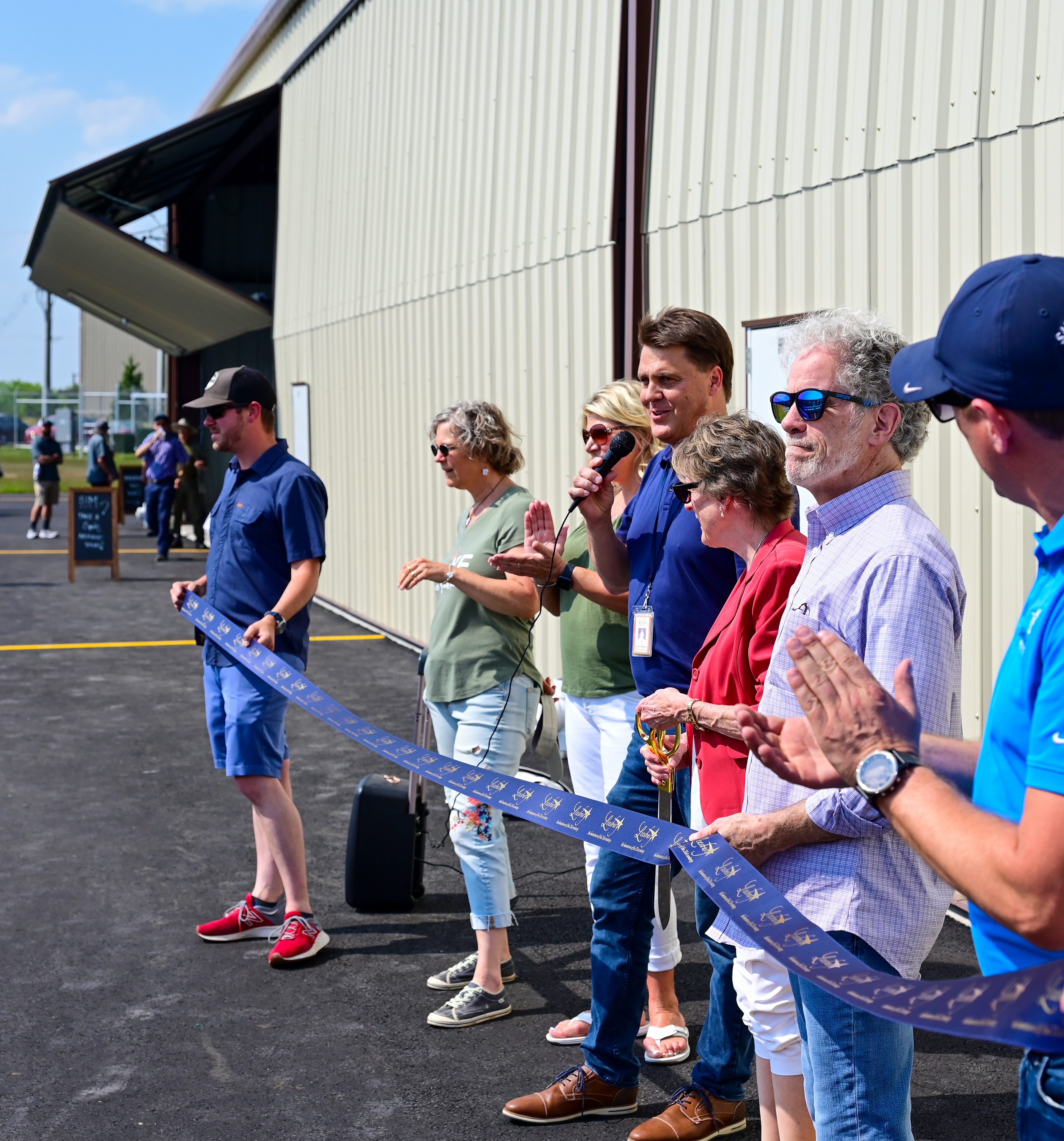 Leesburg Executive Airport Director Scott Coffman welcomes attendees to a ribbon cutting ceremony for new hangars. Photo by David Tulis.