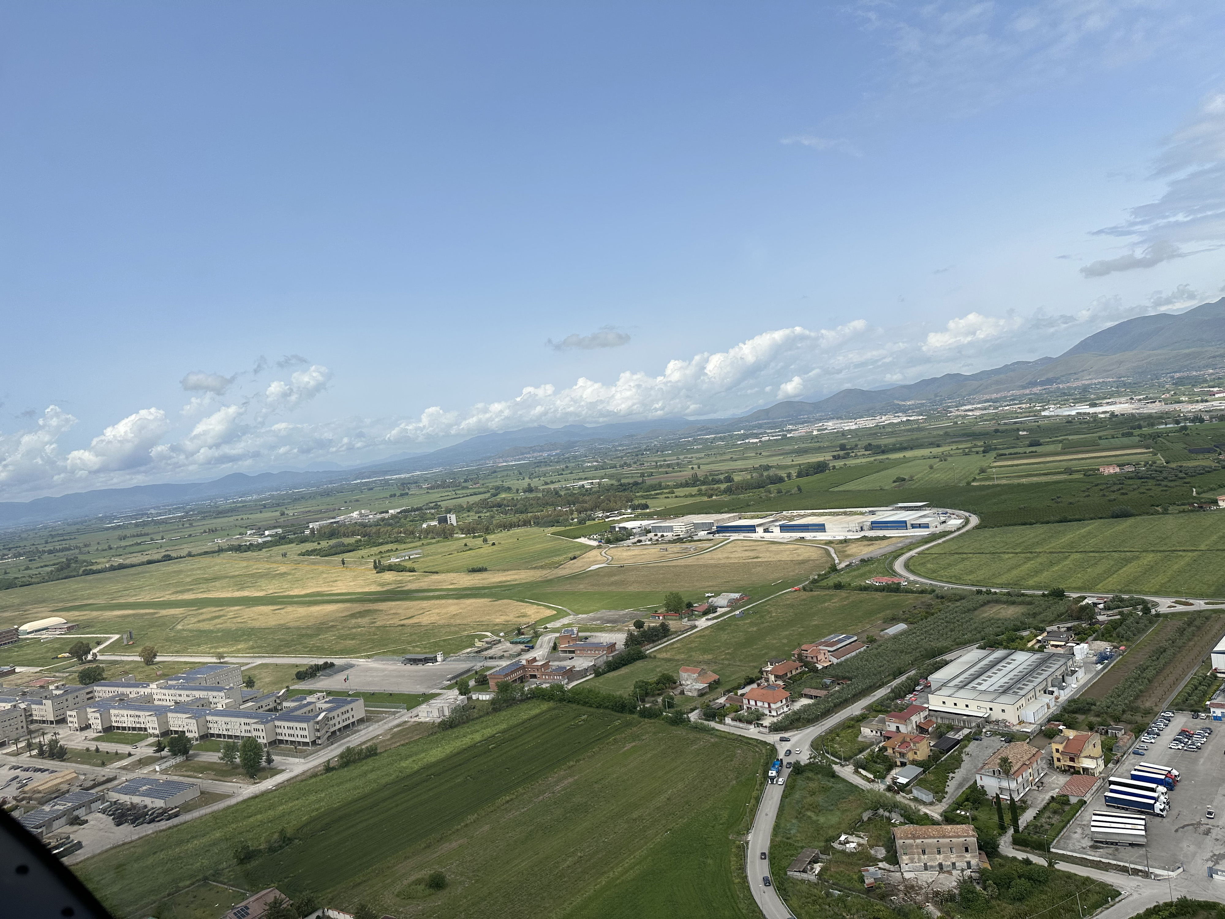Tecnam is expanding its main facility (blue buildings) at the Capua airport, a public airport with a grass strip. Photo by Sarah Deener.