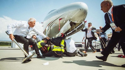 Airport officials in Geneva reported four people were treated for minor injuries after security clashed with climate protesters who chained themselves to parked aircraft. Photo courtesy of Stay Grounded/Greenpeace.