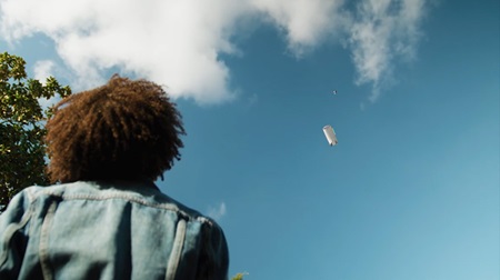 A Zipline drone hovers over a package recipient, lowering another drone on a tether containing the item to be deposited at the feet of the waiting customer. Image courtesy of Zipline. 