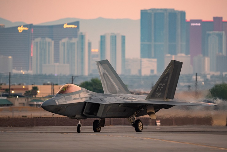 A Lockheed Martin F–22 Raptor taxis at Nellis Air Force Base (with Las Vegas visible in the background) on August 4, 2021. Fighters like this one will guard the Super Bowl, ready to intercept aircraft that may violate the temporary flight restriction that will be in effect on February 11. U.S. Air Force photo by William R. Lewis.