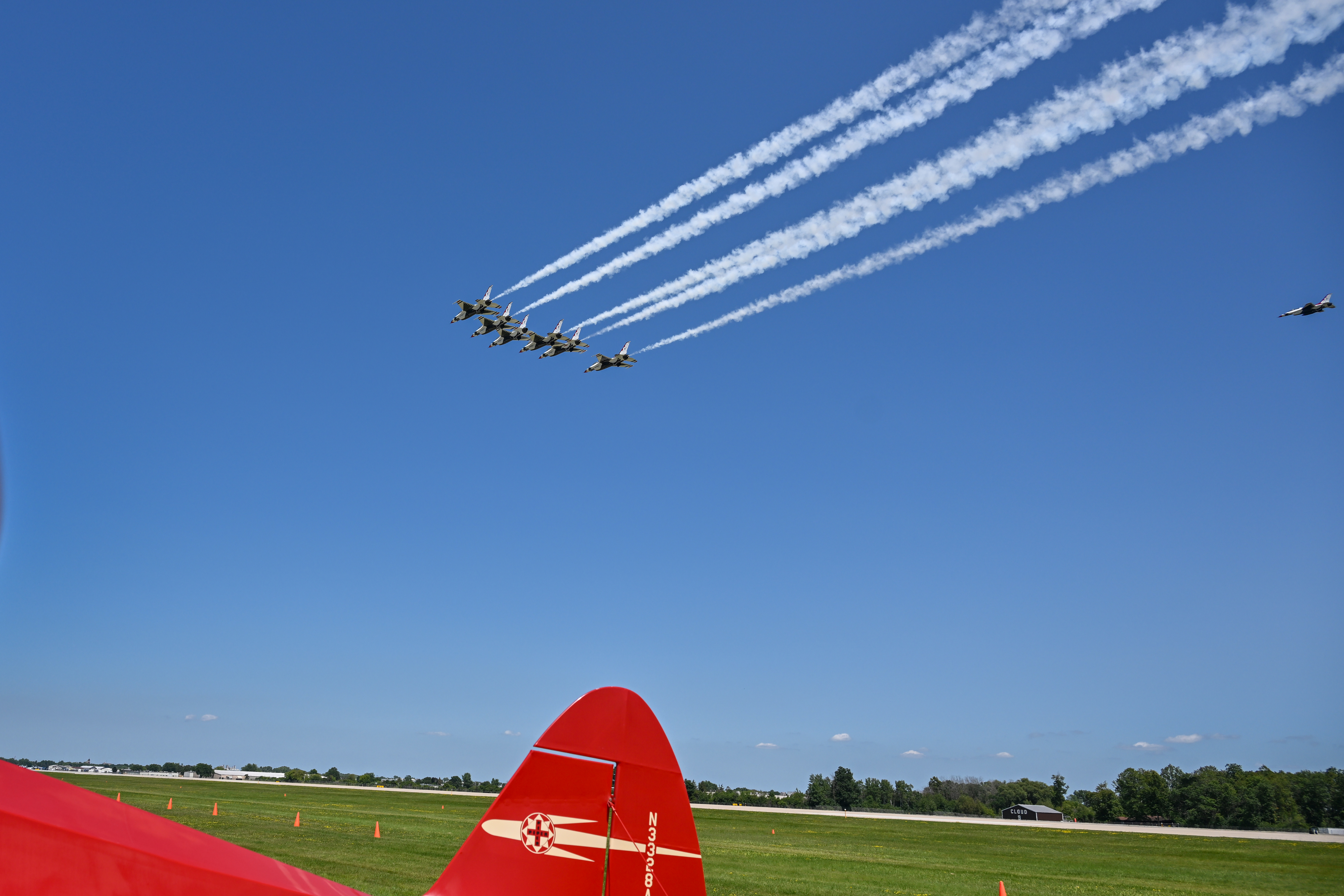 The U.S. Air Force Thunderbirds perform an impromptu flyby over an aircraft positioned for the Vintage in Review portion of the Thursday afternoon airshow. Photo by David Tulis.